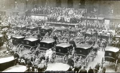 Dozens of horse-drawn carriages carrying coffins of the victims gather outside Ashton Town Hall for the mass funeral (Ashton under Lyne, Ashton-under-Lyne munitions explosion, Funeral, Hooley Hill Rubber and Chemical Works, Town Hall)