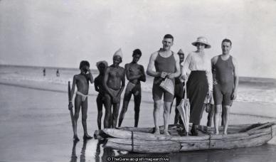 Group with boat on beach India (Beach, Canoe, India, Swimming)