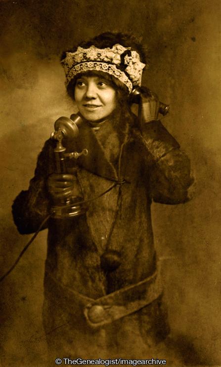 Lady in fur coat hat gloves on candlestick phone C1890_og (C1890, candlestick telephone, fur coat, gloves, hat, Lady, Telephone)