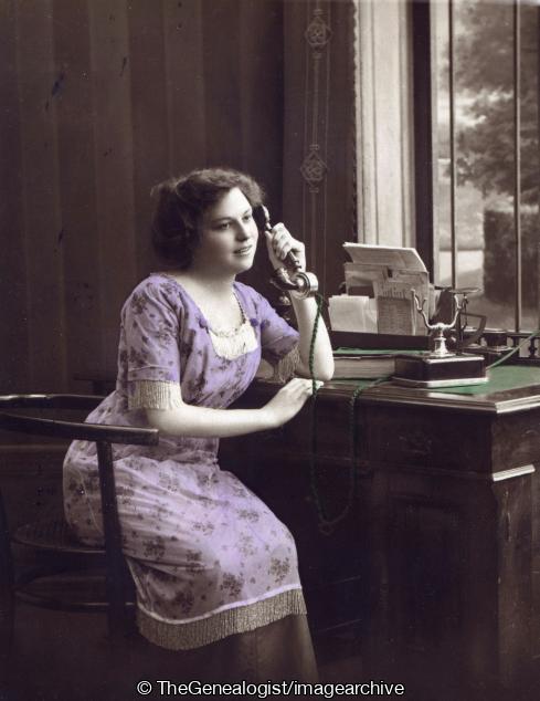 Lady seated at desk on phone C1912 (C1912, desk, Lady, phone, Telephone)